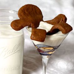 a glass filled with ice cream and cookies next to a jar of milk on a table