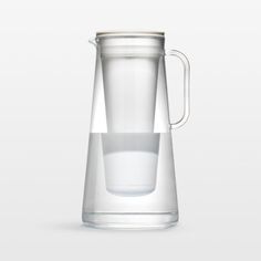 a clear glass pitcher with a white lid on a gray background, filled with water