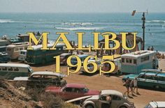 there are many old cars and trucks parked on the beach next to the ocean with people in the water