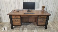 a wooden desk with a computer monitor and keyboard sitting on it's top shelf