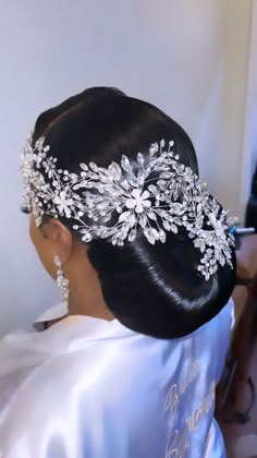 a woman wearing a bridal hair comb with flowers on it's head and pearls in her hair