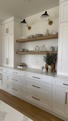 the kitchen is clean and ready to be used for cooking or baking, with white cabinets and brass pulls