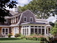 a large house with lots of windows on the front and side of it's roof