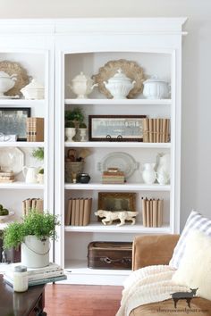 a living room filled with furniture and bookshelves covered in white bookcases