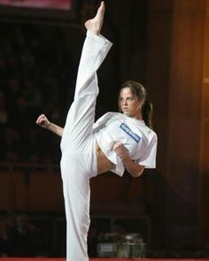 a woman in white is doing karate