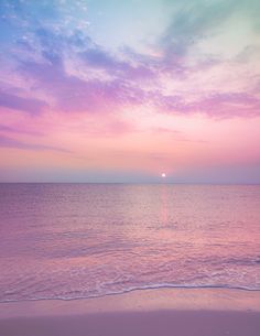 the sun is setting over the ocean with pink clouds