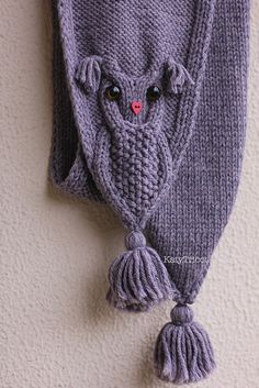 a knitted owl hat hanging on the wall