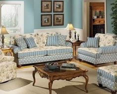 a living room with blue walls and floral furniture in it's centerpieces