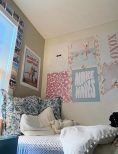 a bedroom with posters on the wall and a bed in front of a large window