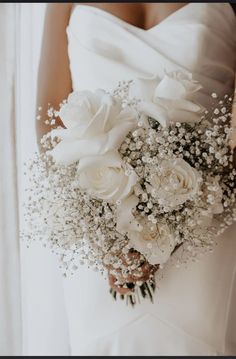 a bridal bouquet with white roses and baby's breath