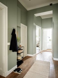 a hallway with green walls and wooden floors