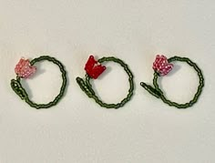 three pieces of green string with pink bows and hearts on them, sitting next to each other