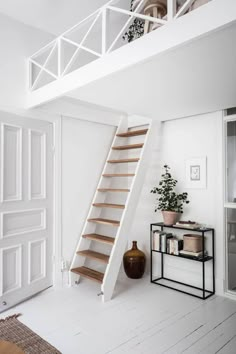 a room with white walls and wooden stairs