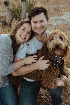 a man and woman are hugging their dog