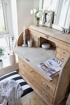 a wooden dresser sitting next to a window