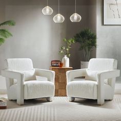 two white chairs sitting next to each other in a living room