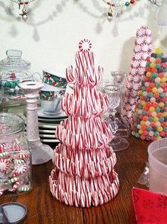 candy cane christmas trees on a table in front of many other candies and decorations