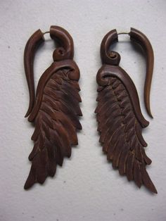 BROWN SAndalWOOD SERAPHIM WING FAKE GAUGE EARRINGS These naturally light colored wood seraphim wing hanging fake gauge earrings were hand carved in Bali, Indonesia from a local hard wood called sawo in Indonesian, or sabe in Balinese. These fake gauge earrings have a steel post connecting the front hook part to the back wing part of the earrings.   Approximate dimensions: 3.25" tall x 1.5" wide These fake gauge earrings have 18 gauge steel posts that fit "normal" un-stretched piercings.  But when worn, they give the appearance of being about 2 gauge size. CUSTOMER NOTE: ITEM IN PICTURES IS THE ITEM THAT YOU WILL RECEIVE MAKE SURE THAT YOU LOOK AT THE PICTURES AND NOTE ANY DAMAGES BEFORE PURCHASING IF YOU HAVE ANY ADDITIONAL QUESTIONS OR WOULD LIKE ANY OTHER SPECIFIC PICTURES BE SURE TO CON Fake Gauge Earrings, Gauge Earrings, Fake Gauges, Light Colored Wood, Gauged Earrings, Steel Post, Handcrafted Artisan Jewelry, Hard Wood, Wood Earrings