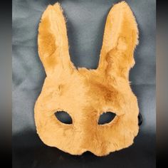 a yellow rabbit mask sitting on top of a black cloth