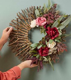 a person placing flowers on the front of a wreath