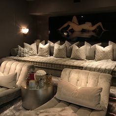 a living room filled with lots of couches and pillows on top of each other