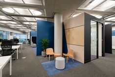 an office with blue and white walls, two yellow chairs and one orange chair in the middle