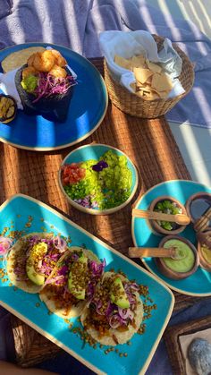 plates with food on them sitting on a table next to bowls and utensils