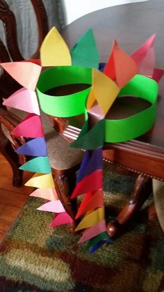 a wooden table topped with lots of colorful pieces of paper sitting on top of a rug