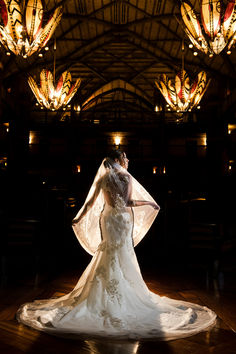 a bride and groom standing in front of chandeliers