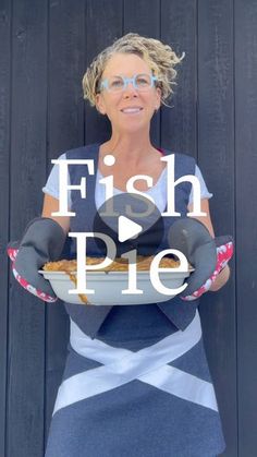 a woman holding a plate with fish pie on it and the words fish pie above her