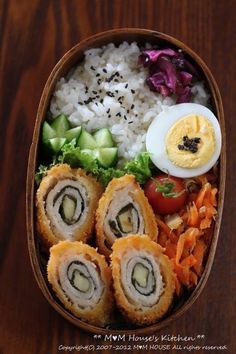 a bento box filled with rice, meat and veggies next to an egg