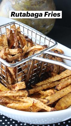 two baskets filled with fried food sitting on top of a white plate next to a black and white polka dot table cloth