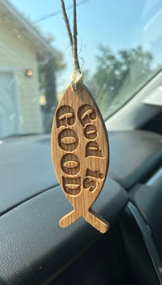 a wooden keychain hanging from the dashboard of a car