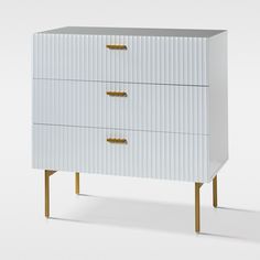 a white dresser with gold handles and drawers