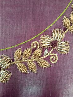 a close up of a piece of cloth with gold thread and flowers on the side