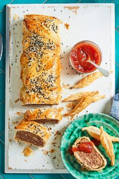 an assortment of pastries on a tray next to a bowl of ketchup