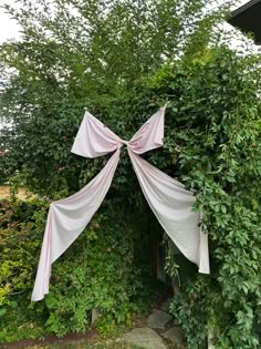 an arch made out of cloth hanging from it's sides in front of some trees