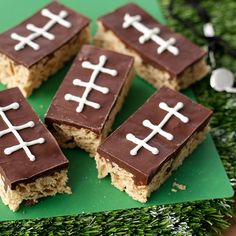 four pieces of rice krispy treats with chocolate and white crosses on them sitting on a green plate