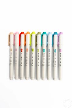 six pens are lined up in a row on a white surface with the same color