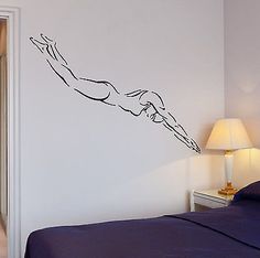 a bed room with a neatly made bed and a wall sticker