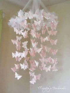 pink and white butterfly mobile hanging from the ceiling