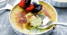 a bowl filled with pudding and fruit on top of a table next to a spoon