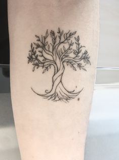 a small tree tattoo on the leg