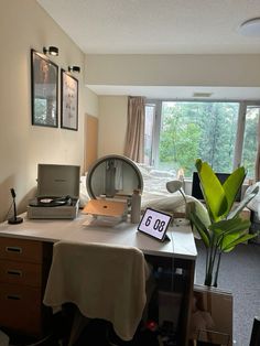 a room with a bed, desk and computer on it in front of a window