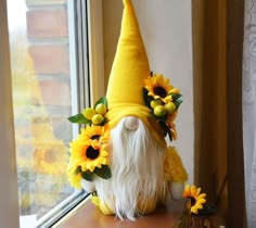 a stuffed gnome with sunflowers on his head sitting next to a window sill