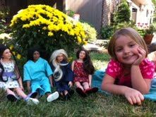 a group of dolls sitting in the grass