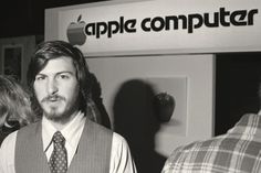 black and white photograph of man in front of an apple computer store with people looking at him