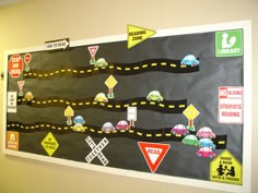 a bulletin board with various road signs and traffic signs on it's side wall