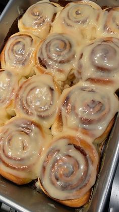 a pan filled with cinnamon rolls sitting on top of a stove