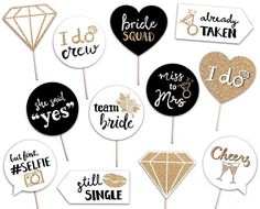 wedding photo booth props with gold glitter and black heart shaped signs on top of them